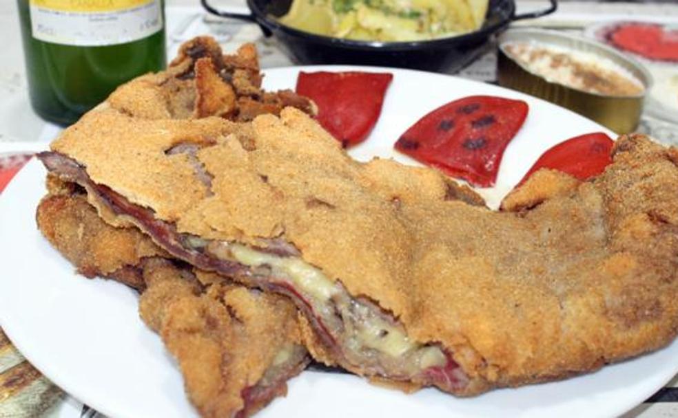 El cachopo tradicional está compuesto de solomillo de cerdo ibérico, jamón serrano de hembra o cecina de León y queso de Vidiago o Cabrales
